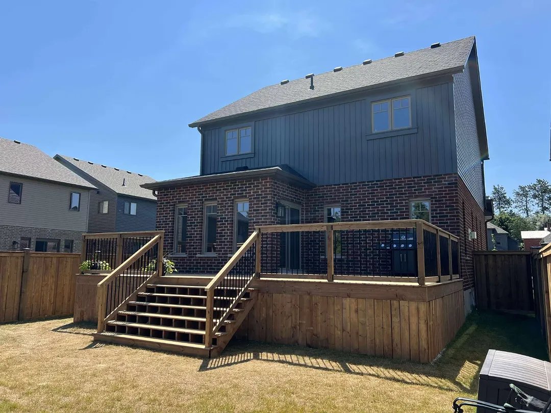 A full width deck with wide stairs down to the yard