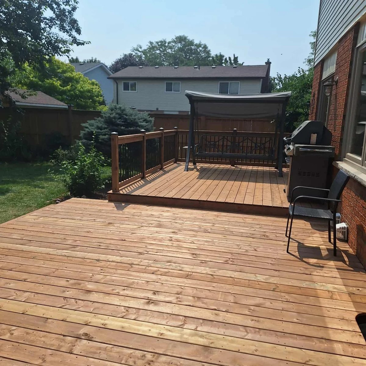 A freshly finished two level deck with a swing seat